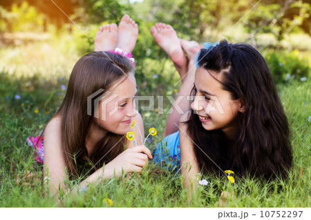 Two sisters laying down in the park 10752297