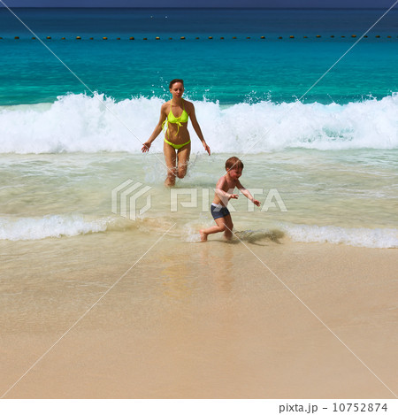 Mother and two year old boy playing on beach 10752874