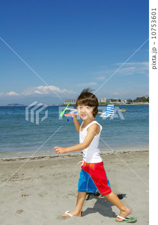 海に向かって飛行機を飛ばそうとしている子供 海に向かって飛行機を飛ばそうとしている子供 10753601