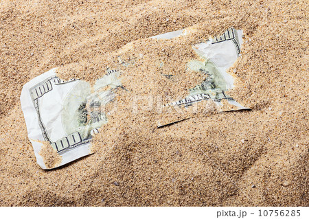 100 dollar bill buried in the sand 10756285