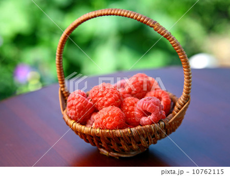 Full basket of red raspberries on the table 10762115