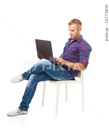 Young man sitting in chair and working on lapto 10773830