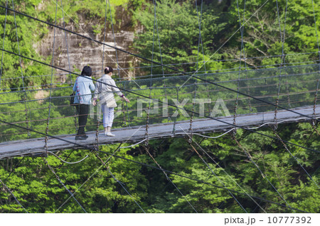 吊り橋を渡る女性 10777392