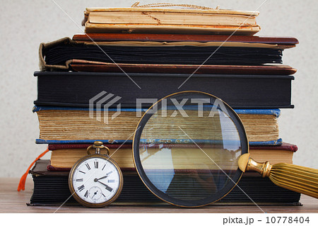 antique clock with loupe  on books background 10778404