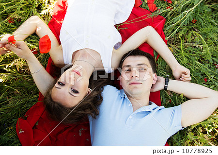 Young happy couple on a meadow full of poppies 10778925
