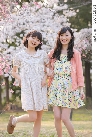 桜の木の下で春を楽しむ若い2人の女性 桜の木の下で春を楽しむ若い2人の女性 10791961