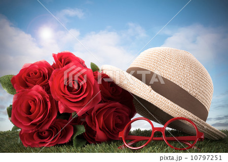 red roses and glasses on green grass with blue sky red roses and glasses on green grass with blue sky 10797251