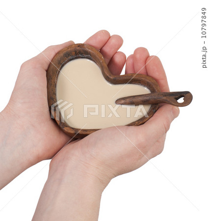 Clay cup in the form of heart with a spoon in hands 10797849