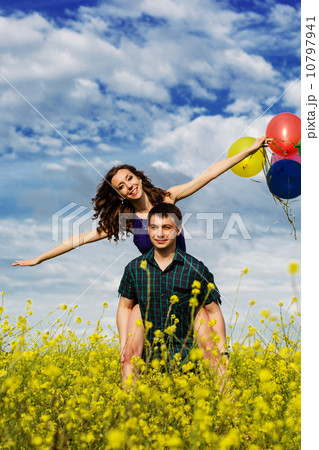 Happy couple with balloons on the yellow field Happy couple with balloons on the yellow field 10797941