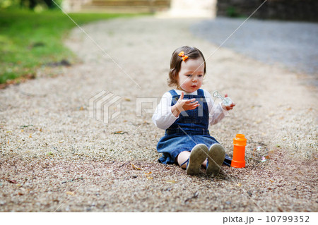 Little cute baby girl playing with soap bubbles in summer park 10799352