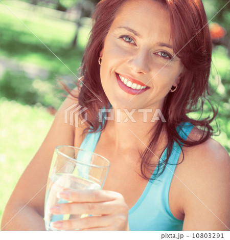 Portrait of young beautiful woman drinking water on picnic 10803291