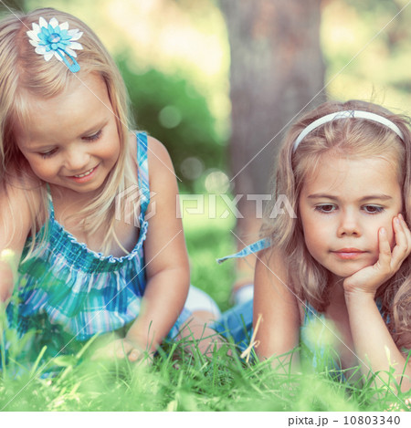 Two little sisters having fun in summer park Two little sisters having fun in summer park 10803340
