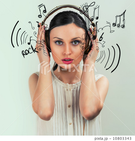 Girl with headphones on the grey background Girl with headphones on the grey background 10803343