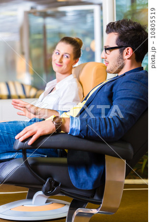 Couple buying armchair in furniture store 10805519