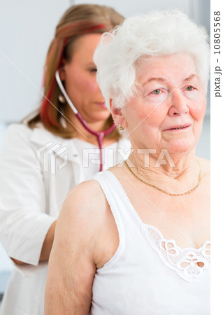 Doctor auscultating senior patient in practice 10805568