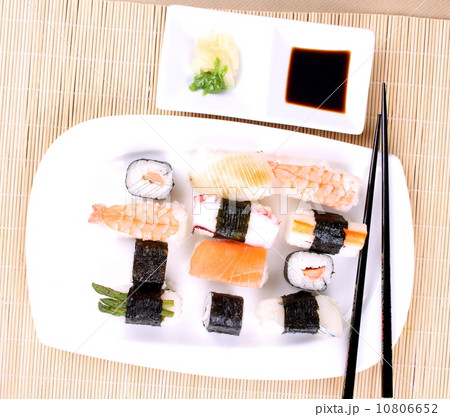 Sushi on a white plate with chopsticks Sushi on a white plate with chopsticks 10806652