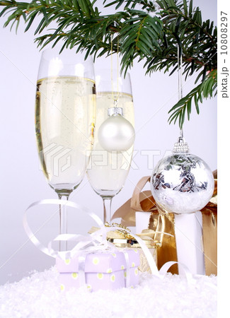 Silver New Year's ball on a Christmas tree branch with gifts and champagne Silver New Year's ball on a Christmas tree branch with gifts and champagne 10808297