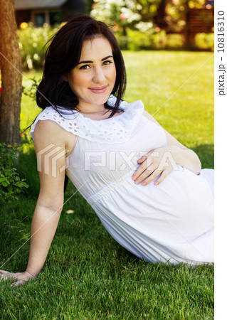 Pregnant woman resting in park with green grass Pregnant woman resting in park with green grass 10816310