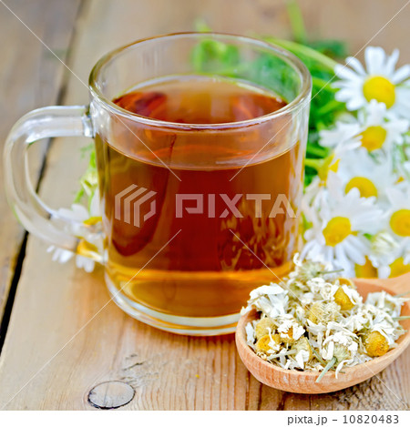 Herbal chamomile tea in glass mug on board Herbal chamomile tea in glass mug on board 10820483