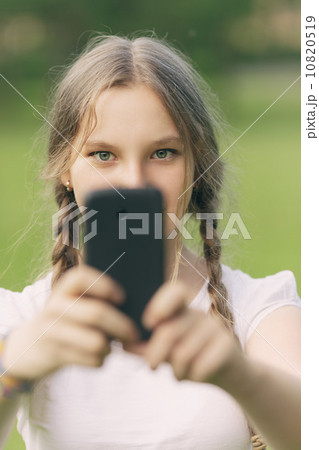 teenage girl taking photo with smartphone teenage girl taking photo with smartphone 10820519