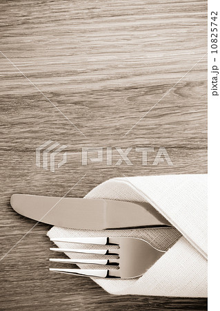 knife and fork at napkin on wood knife and fork at napkin on wood 10825742