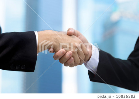 Close up of two successful entrepreneur business men shaking hands in front of glass office building Close up of two successful entrepreneur business men shaking hands in front of glass office building 10826582