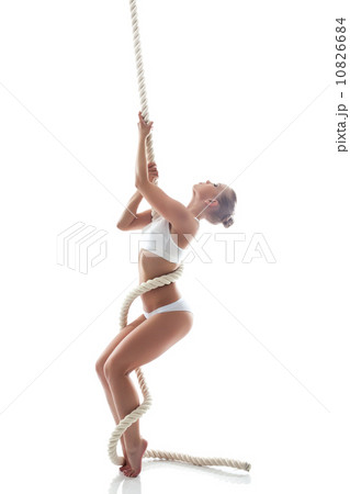 Flexible aerialist posing on rope in studio Flexible aerialist posing on rope in studio 10826684
