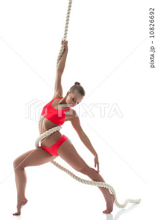 Slender young girl hanging on rope in studio Slender young girl hanging on rope in studio 10826692