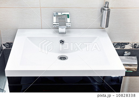White sink and soap dispenser. 10828338
