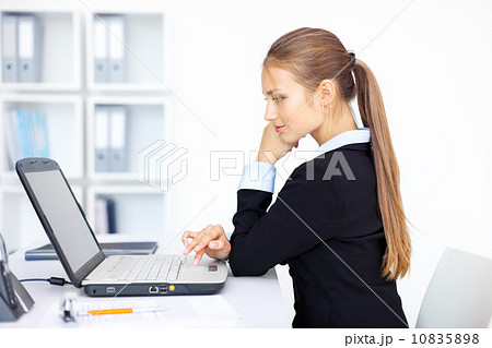 Portrait of beautiful young smiling business woman working on a 10835898