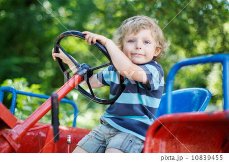 Portrait of little blond boy in tractor in summer 10839455