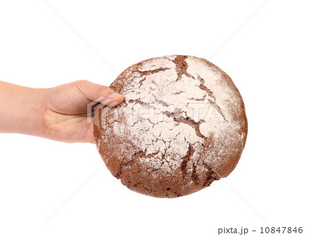 Hand holds brown round bread. 10847846
