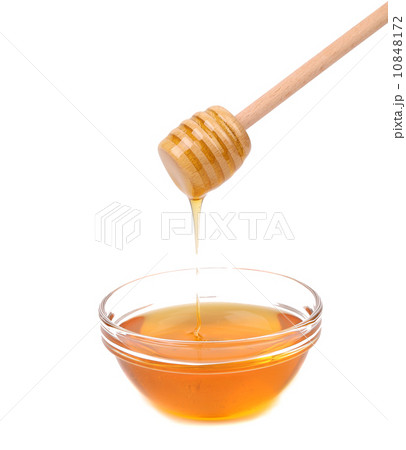 Honey dripping from a wooden dipper. Honey dripping from a wooden dipper. 10848172