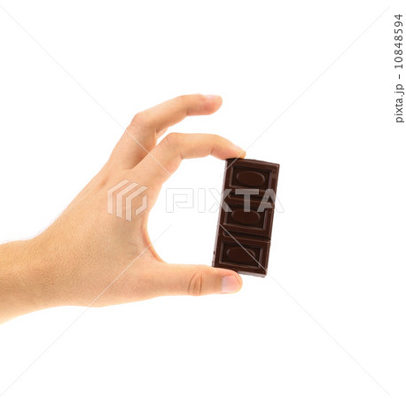 Hand holds dark chocolate bar. 10848594