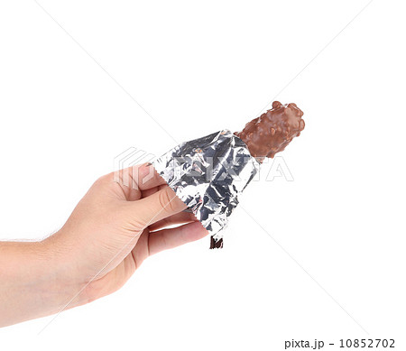 Hand holds bar chocolate in foil. Hand holds bar chocolate in foil. 10852702