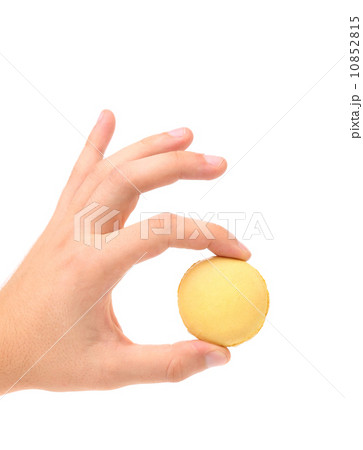 Hand holds traditional French yellow macaron. Hand holds traditional French yellow macaron. 10852815