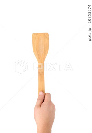 Hand holds woodfen spatula. Hand holds woodfen spatula. 10853574