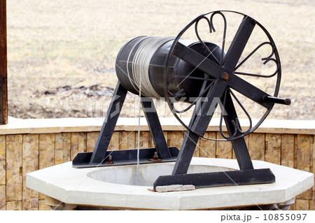 Old water well with pulley 10855097