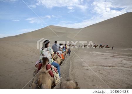 DUNHUANG, CHINA-August 22: camels walking in the Mingsha sand dunes mountain on August 22, 2013 in Dunhuang, China. DUNHUANG, CHINA-August 22: camels walking in the Mingsha sand dunes mountain on August 22, 2013 in Dunhuang, China. 10860488