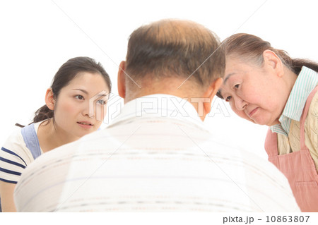 男性の様子を見るエプロン姿の女性二人 10863807