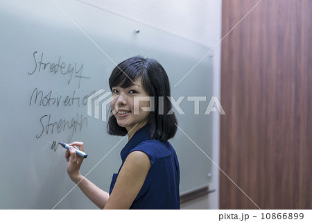 A young chinese female executive preparing presentation on a white board 10866899
