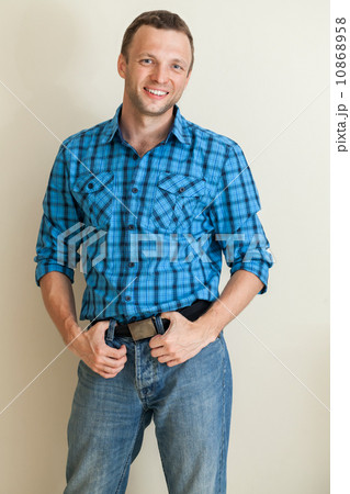 Studio portrait of young positive Caucasian man in blue shirt 10868958