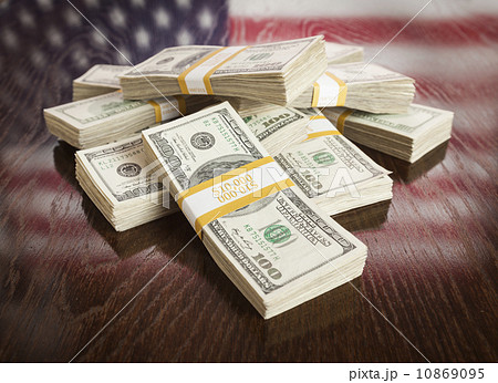 Thousands of Dollars with Reflection of American Flag on Table 10869095