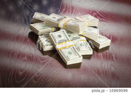 Thousands of Dollars with Reflection of American Flag on Table 10869096