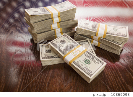 Thousands of Dollars with Reflection of American Flag on Table Thousands of Dollars with Reflection of American Flag on Table 10869098