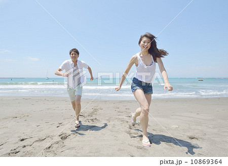 砂浜を走る若いカップル 砂浜を走る若いカップル 10869364