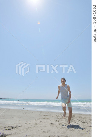 ビーチを走る若い男性 10871062