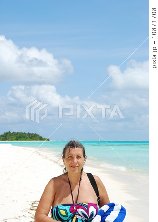 Beautiful senior woman walking on a tropical beach Beautiful senior woman walking on a tropical beach 10871708