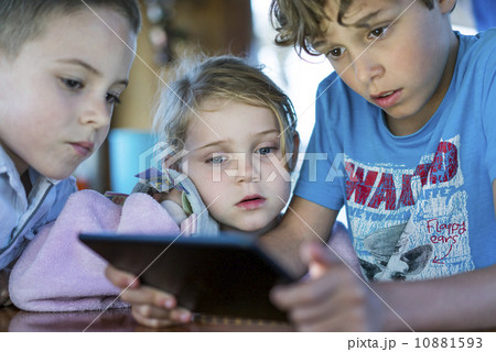 Caucasian children playing games on tablet computer Caucasian children playing games on tablet computer 10881593