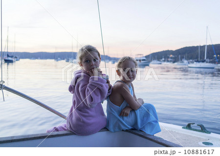 Two Caucasian girls sitting next to the sea, enjoying the sunset. Two Caucasian girls sitting next to the sea, enjoying the sunset. 10881617